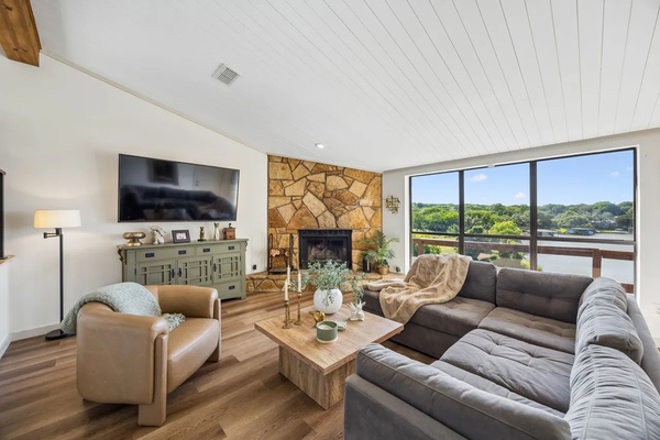 Comfortable living room with fireplace, television, and lake views.