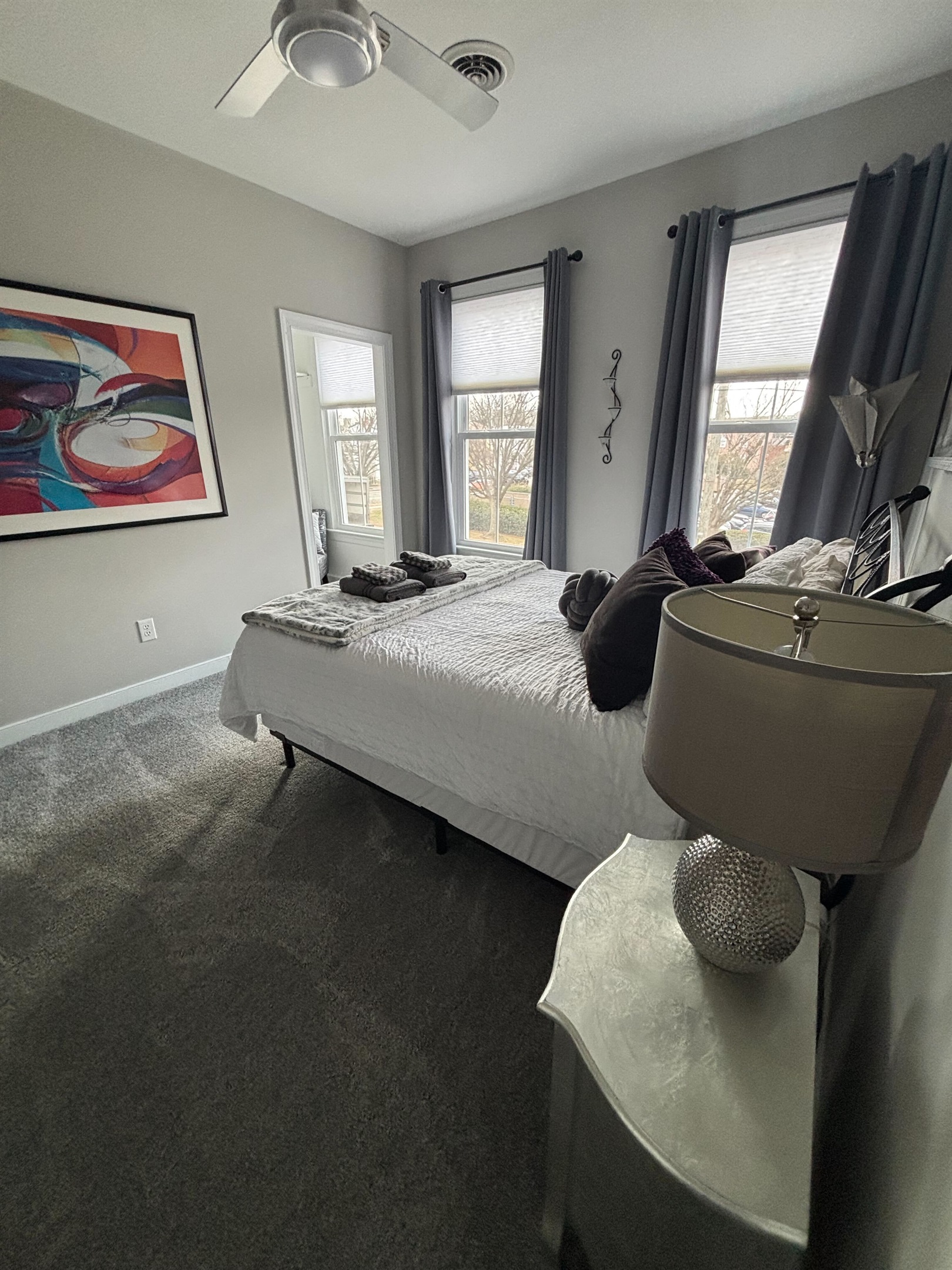 Queen Bedroom 3: Relax on a plush bed adorned with vibrant pillows and gentle natural light. Added Room Darkening Shades