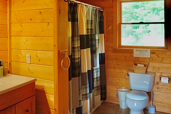 Bright wood accents and a charming shower create a refreshing, rustic vibe!