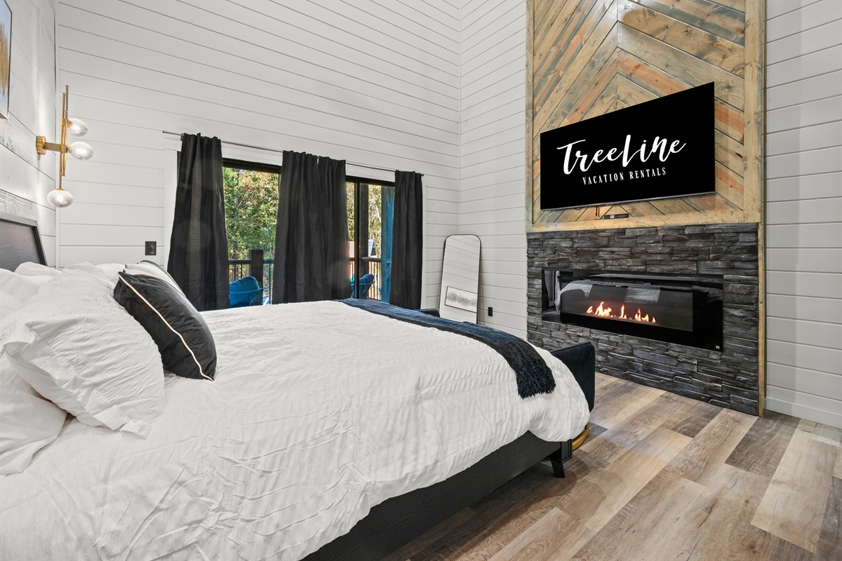 The elegant fireplace and warm tones make this bedroom a cozy place to snuggle up and relax in style.