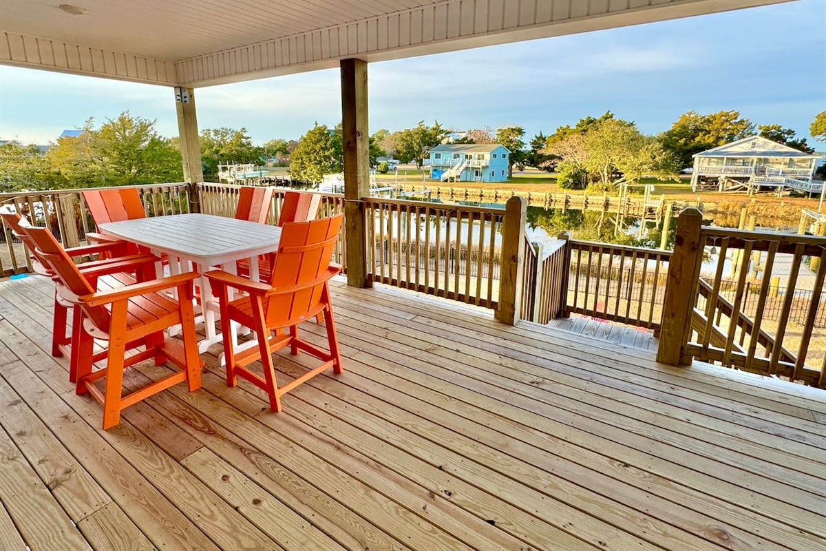 Private backyard dock with boat lift and fillet table, fenced-in backyard, fire pit with Adirondack chairs, hammocks, propane grill, picnic table, outdoor shower, expansive waterfront back deck with table and seating, neighborhood boat ramp and dock
