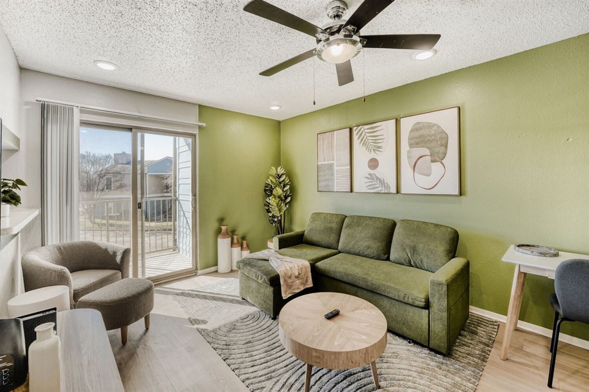 Bright living room with green accents, modern décor, and plenty of natural light.