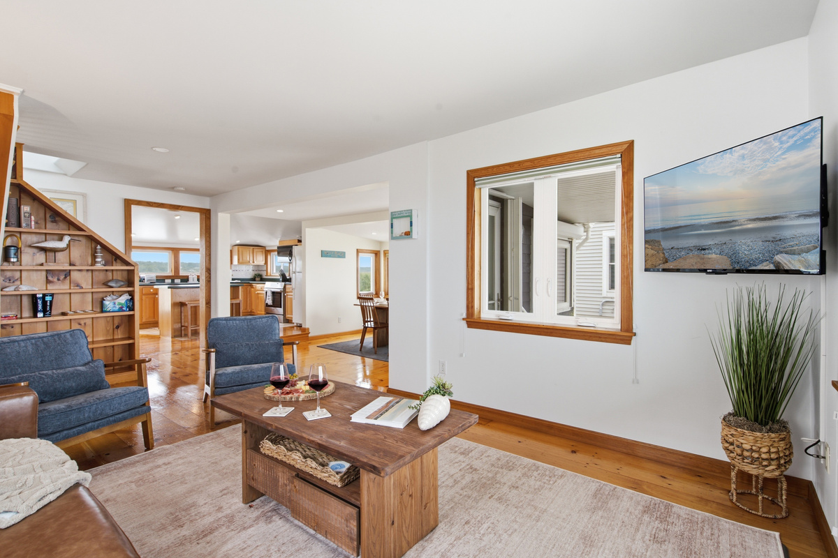 Relax in the open-concept living room with comfortable seating and coastal décor.