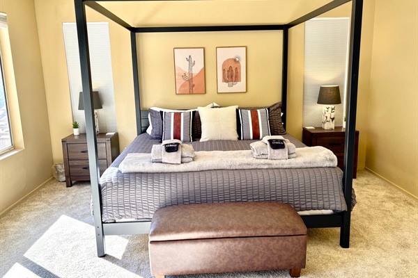 Primary suite with king bed, 55' smart tv, blackout blinds, ceiling fan, remote workstation, walk in closet, ensuite bathroom and private deck