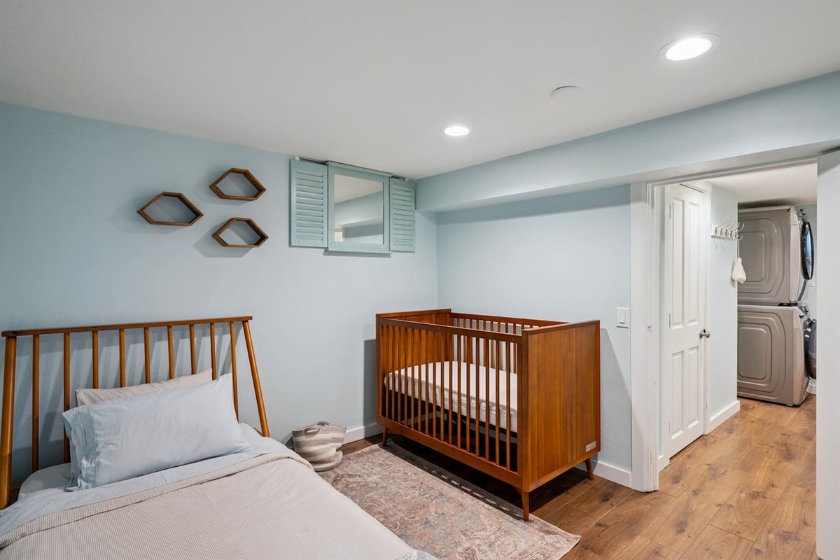 Downstairs bedroom with queen bed and crib