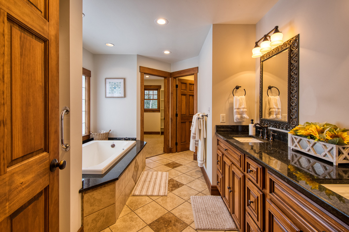 Spa-inspired primary bathroom includes a double vanity, jacuzzi soaking tub, and spacious walk-in shower.