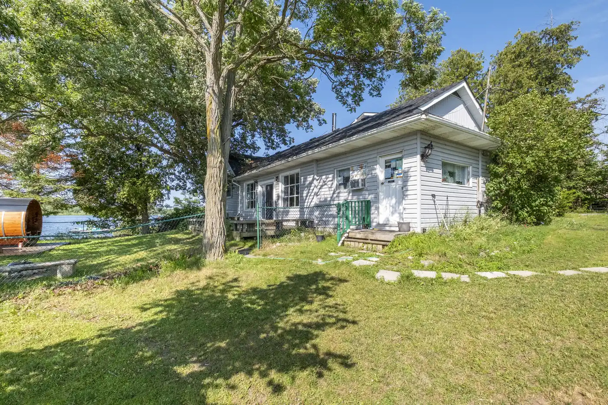 Main House exterior with large grassy yard and shade trees