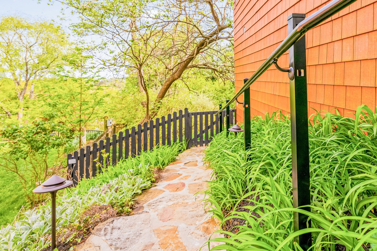 Stone stairs down around the house create another way to move into or out of the lower floor and enjoy gardens too! Take a left off the front porch and use the large, long stone stairs to the Koi Pond deck. Easy peasy!