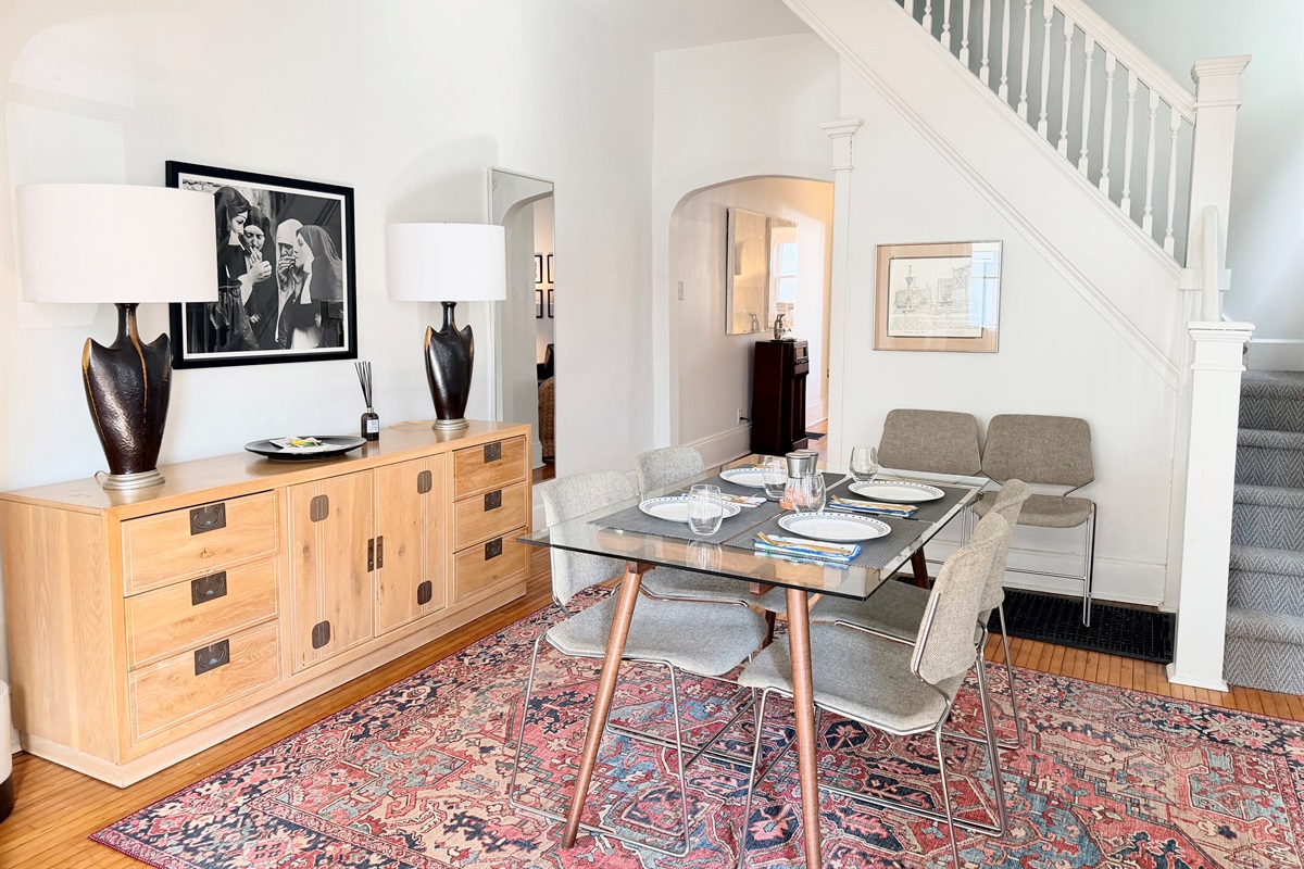 Mid-century modern pieces anchor the dining room, blending vintage character with playful accents, comfortable seating for four and extra cozy seating for up to six.