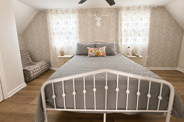 Charming second-floor primary bedroom with a queen bed, natural light and a cozy retreat feel near the upstairs loft and deck.