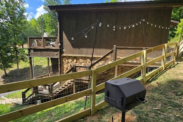 NEW July 2025 - fenced back yard space and charcoal grill near the firepit
