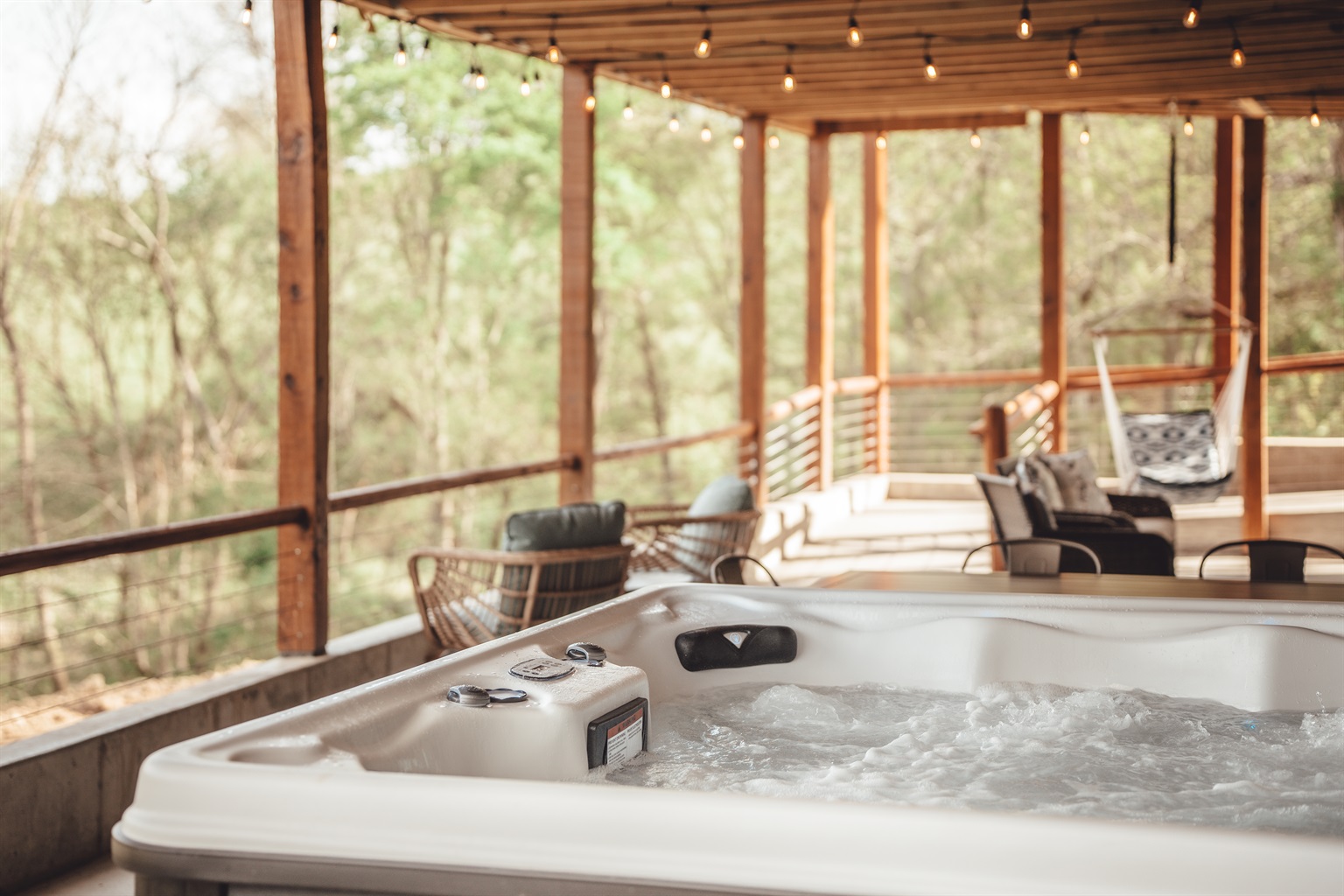 Hot tub on covered deck at a Hocking Hills cabin during rainy weather