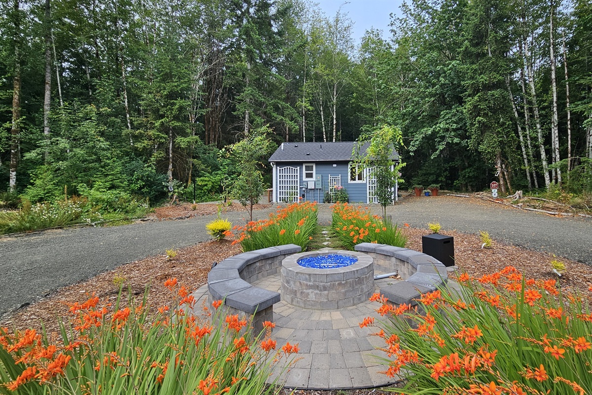 Propane fire pit and seating area between the 105-RV Site and 107-Cottage