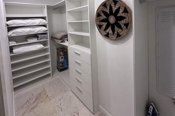 Spacious walk-in closet with ample storage, including hanging rods, shelves, and drawers, perfect for organizing your belongings during your stay.