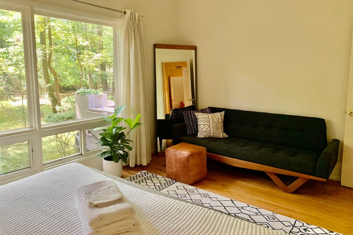 A green velvet couch pulled up to the picture windows makes this the spot for a slow morning coffee with the backyard as your backdrop.