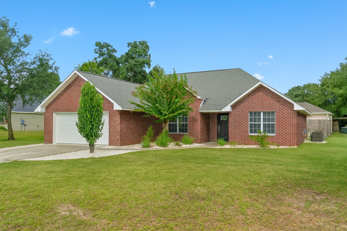 Set on a large lot with lush green grass and stylish landscaping, this red-brick home offers a peaceful escape with plenty of room to roam.