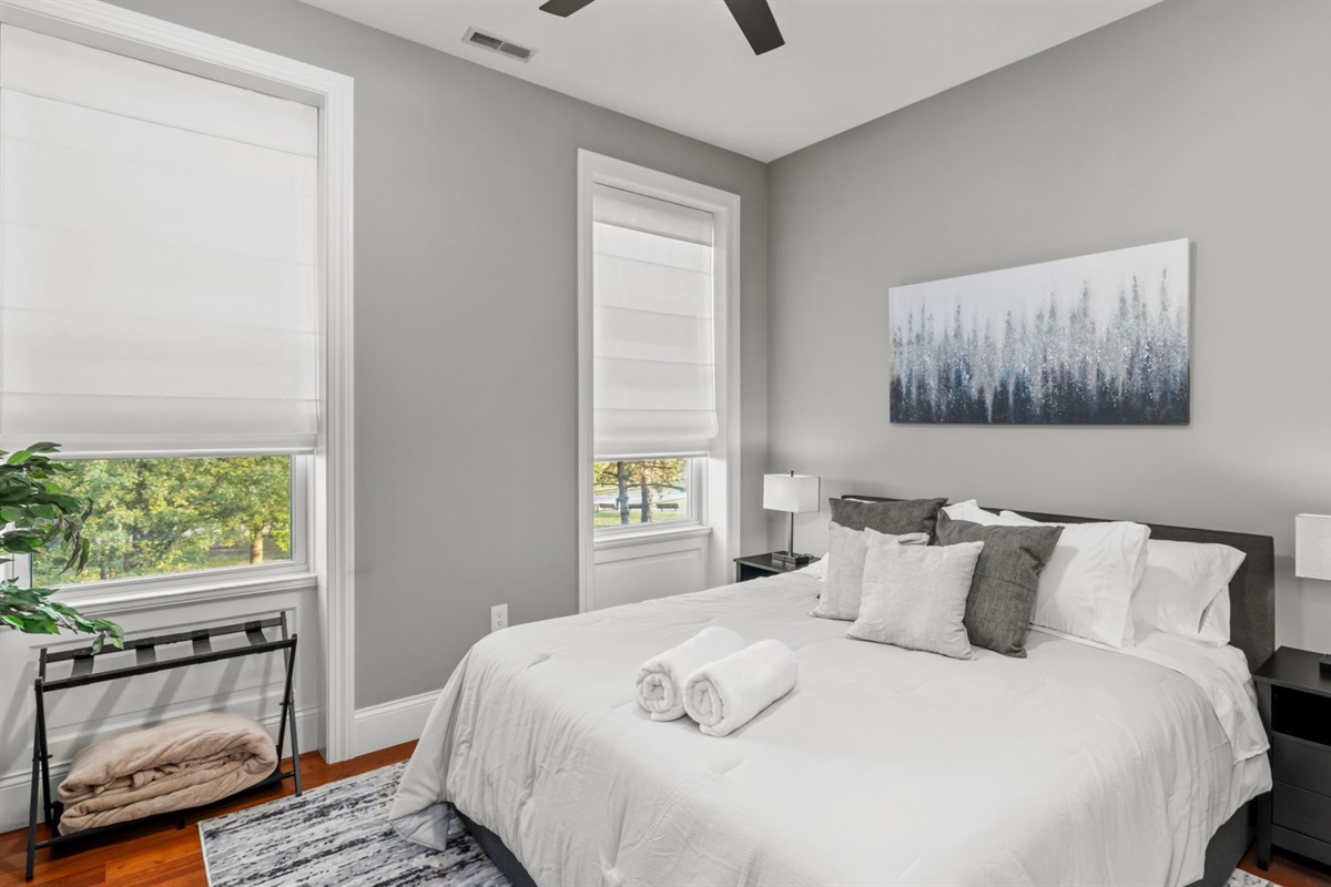 Bedroom 1 is bright and inviting with a king size bed, Smart TV, and spacious closet and dresser.