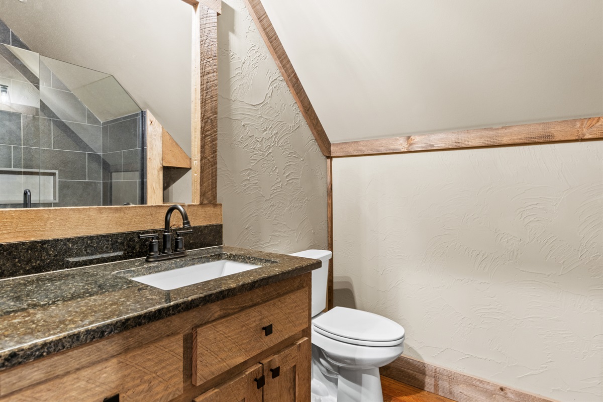 This ensuite bathroom is conveniently located and styled with the same rustic elegance as the rest of the home. 