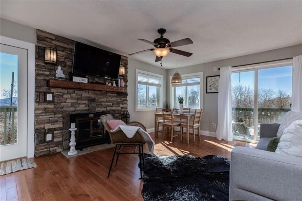 Cozy living room with wood burning fireplace and door leading to balcony.