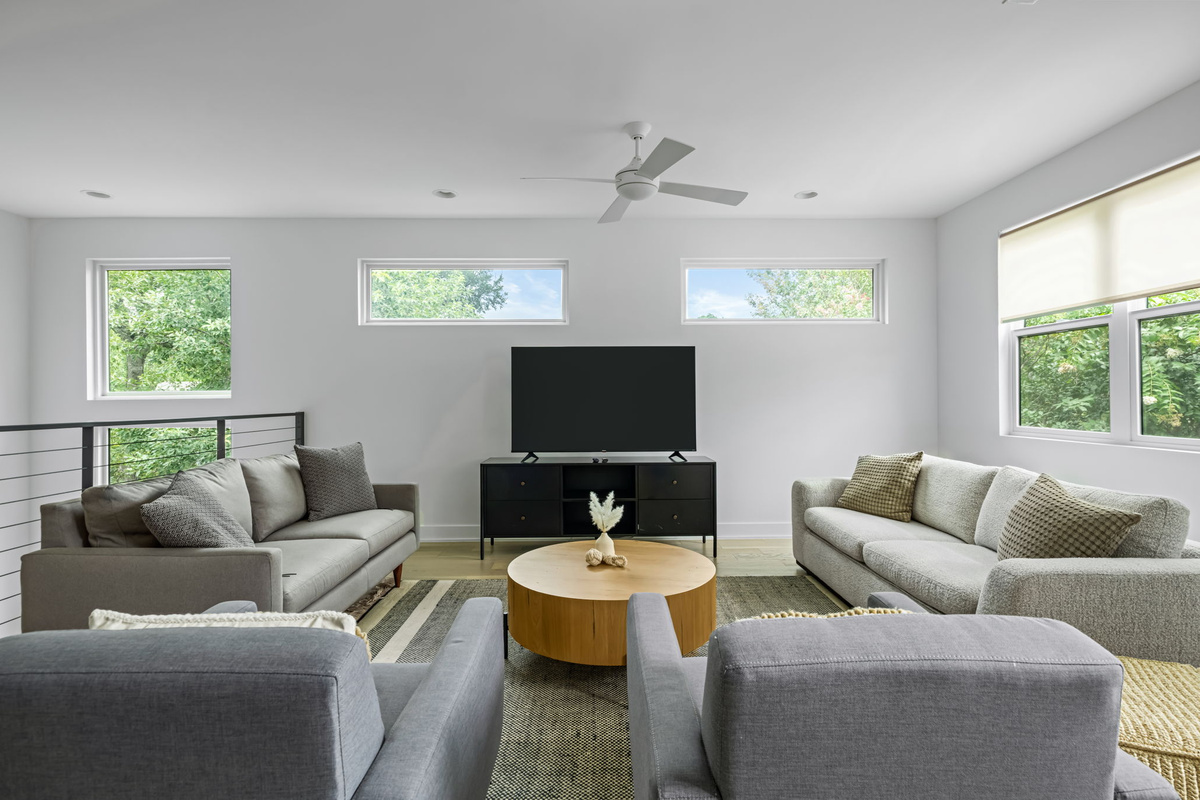 Spacious secondary living area featuring plush seating for the whole group, natural light, and a wood coffee table centerpiece.