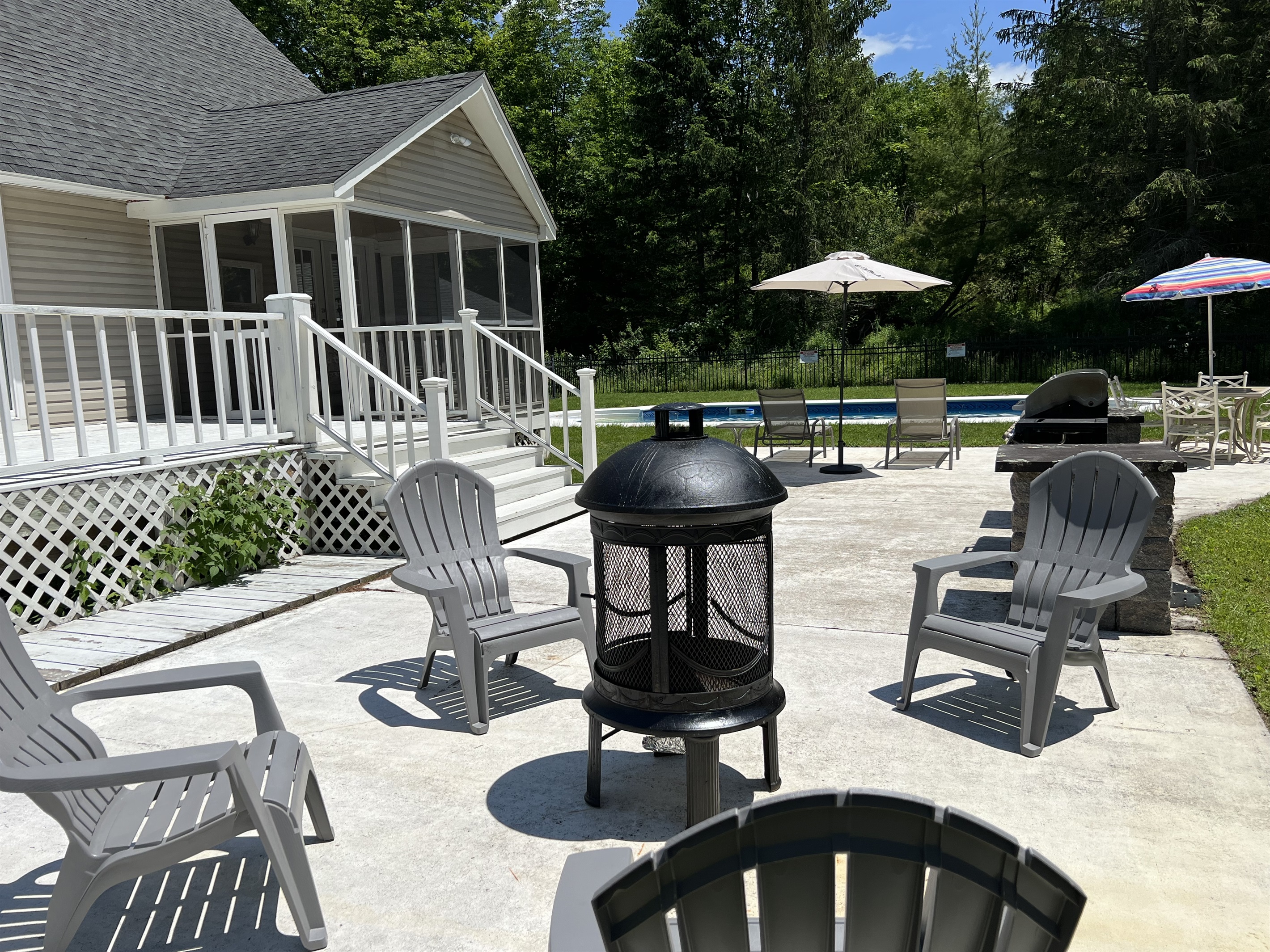 Fire pit on patio with pool beyond