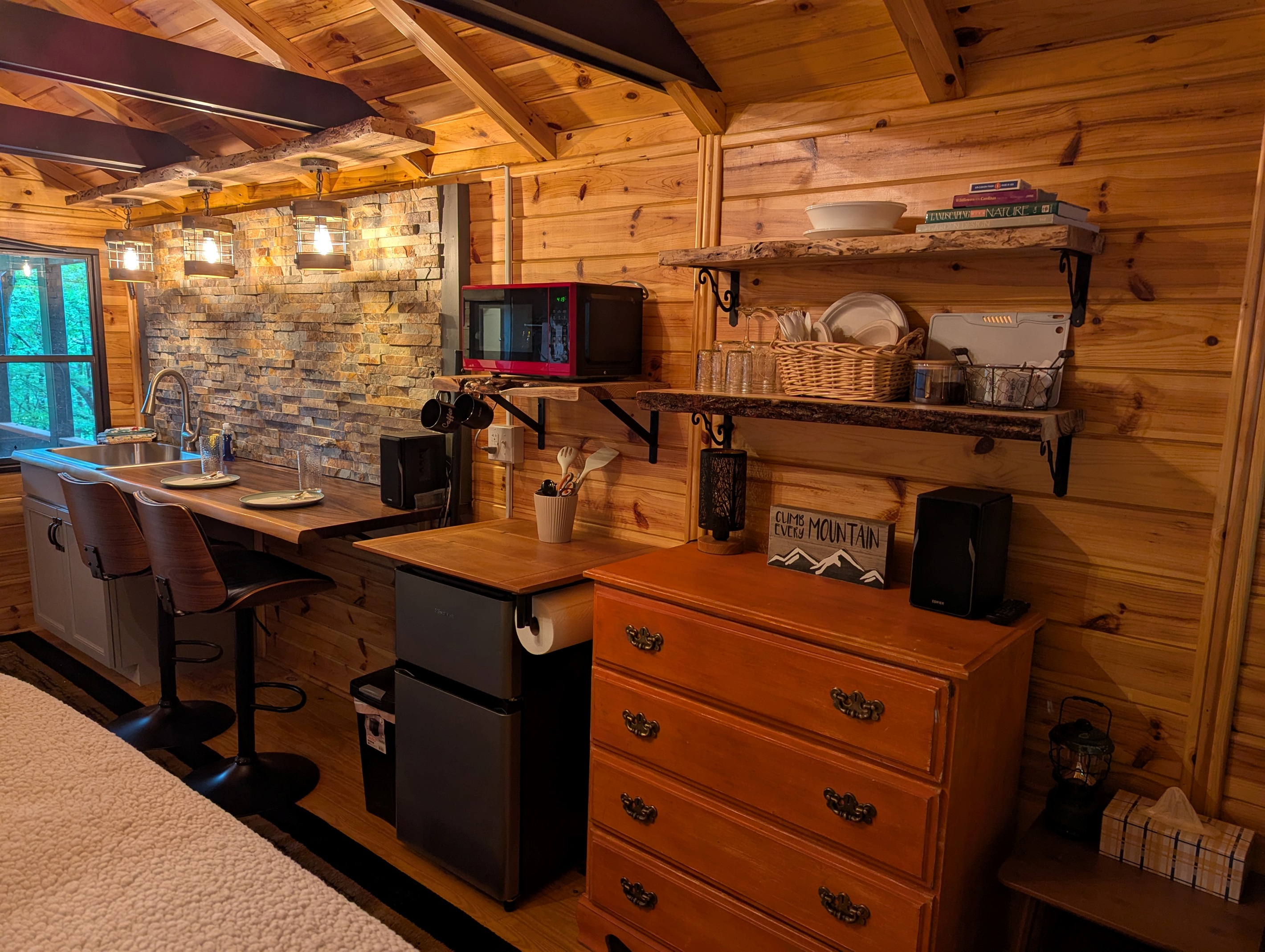 Microwave, Mini Fridge, Coffee Maker, Electric Kettle, and Hot Plate with some pots and skillet provided. 