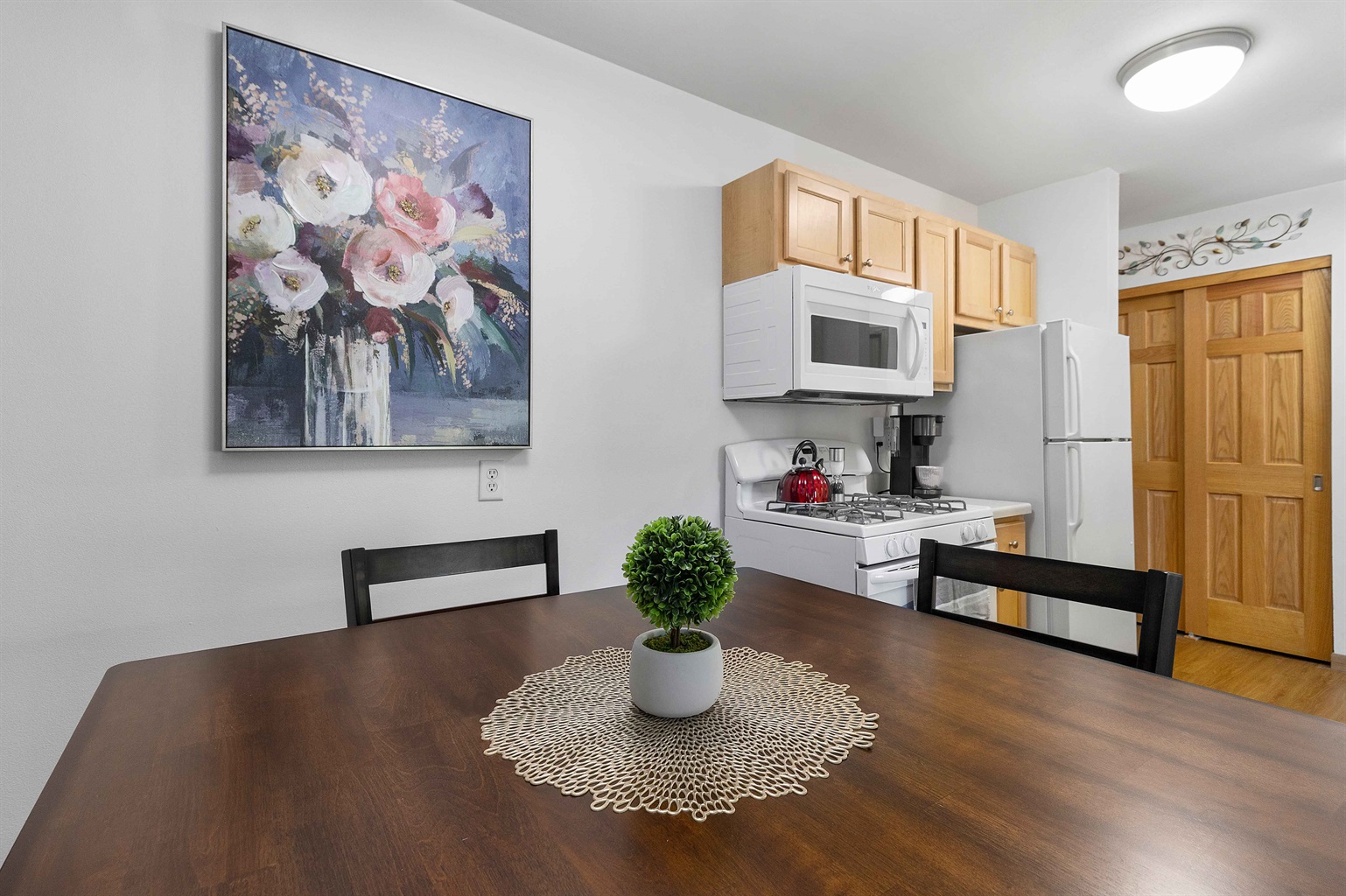 Full size dining table and plenty of storage space in kitchen cabinets.