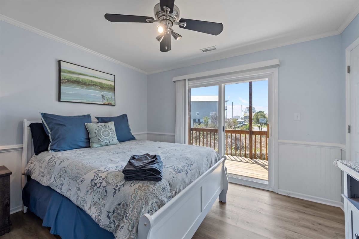 Main floor queen bedroom features private balcony access