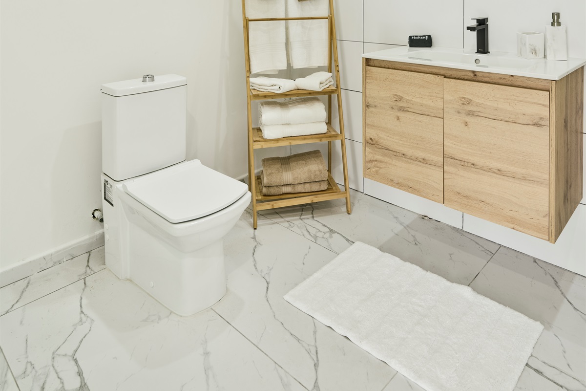 Cozy Half Bath with Modern Toilet & Wooden Ladder Towel Rack