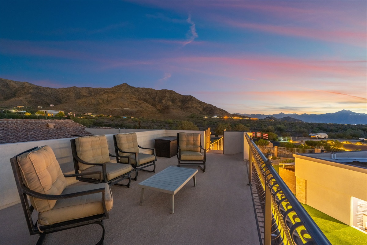 Unwind on the elevated deck as the sky melts into a stunning desert sunset.