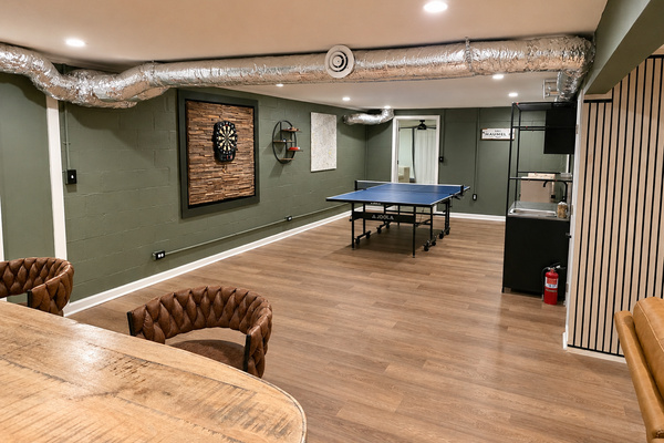 Spacious basement game room with ping pong, darts, bar seating and plenty of room to hang out.