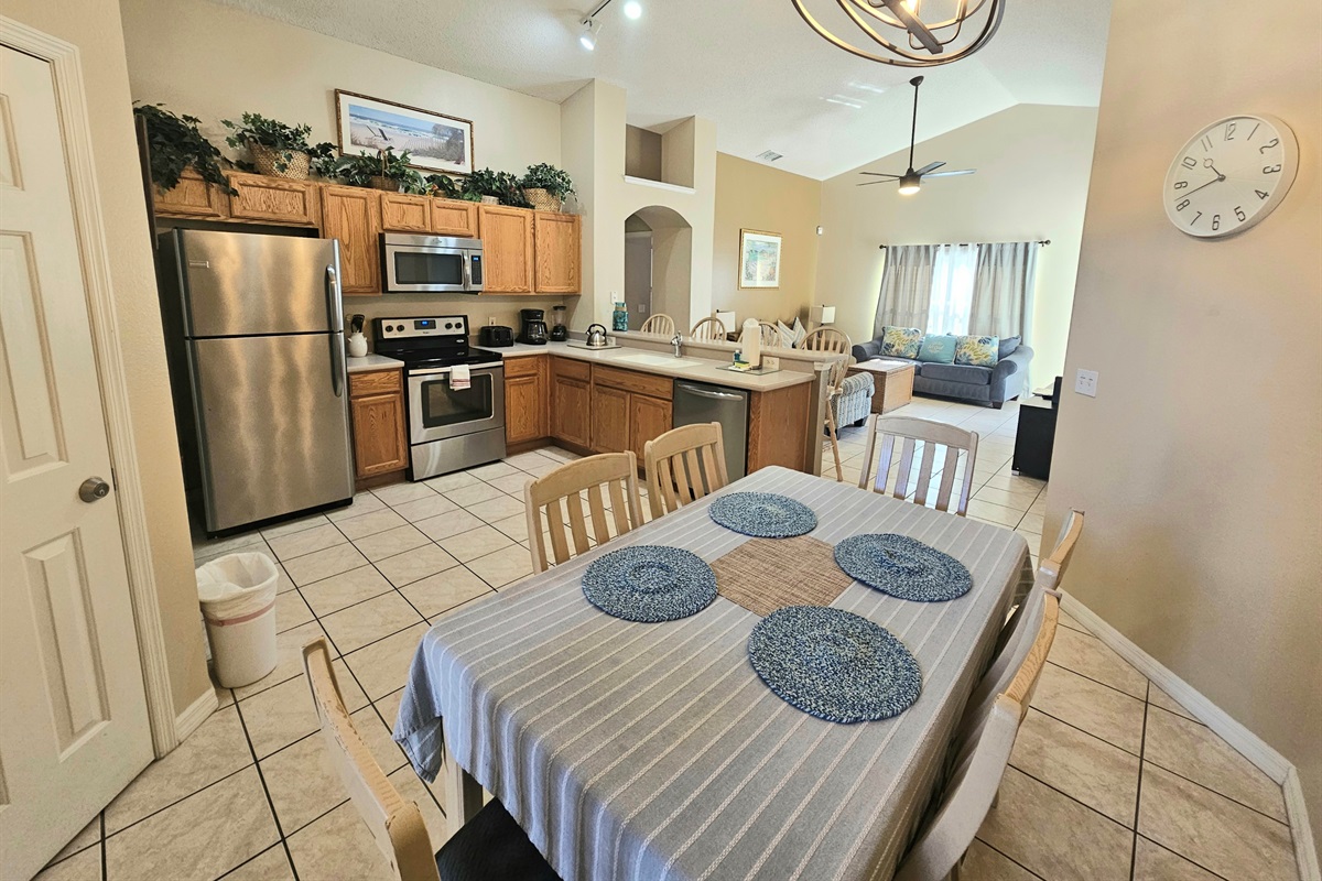 spacious fully equipped kitchen with stainless steel appliances and dining area