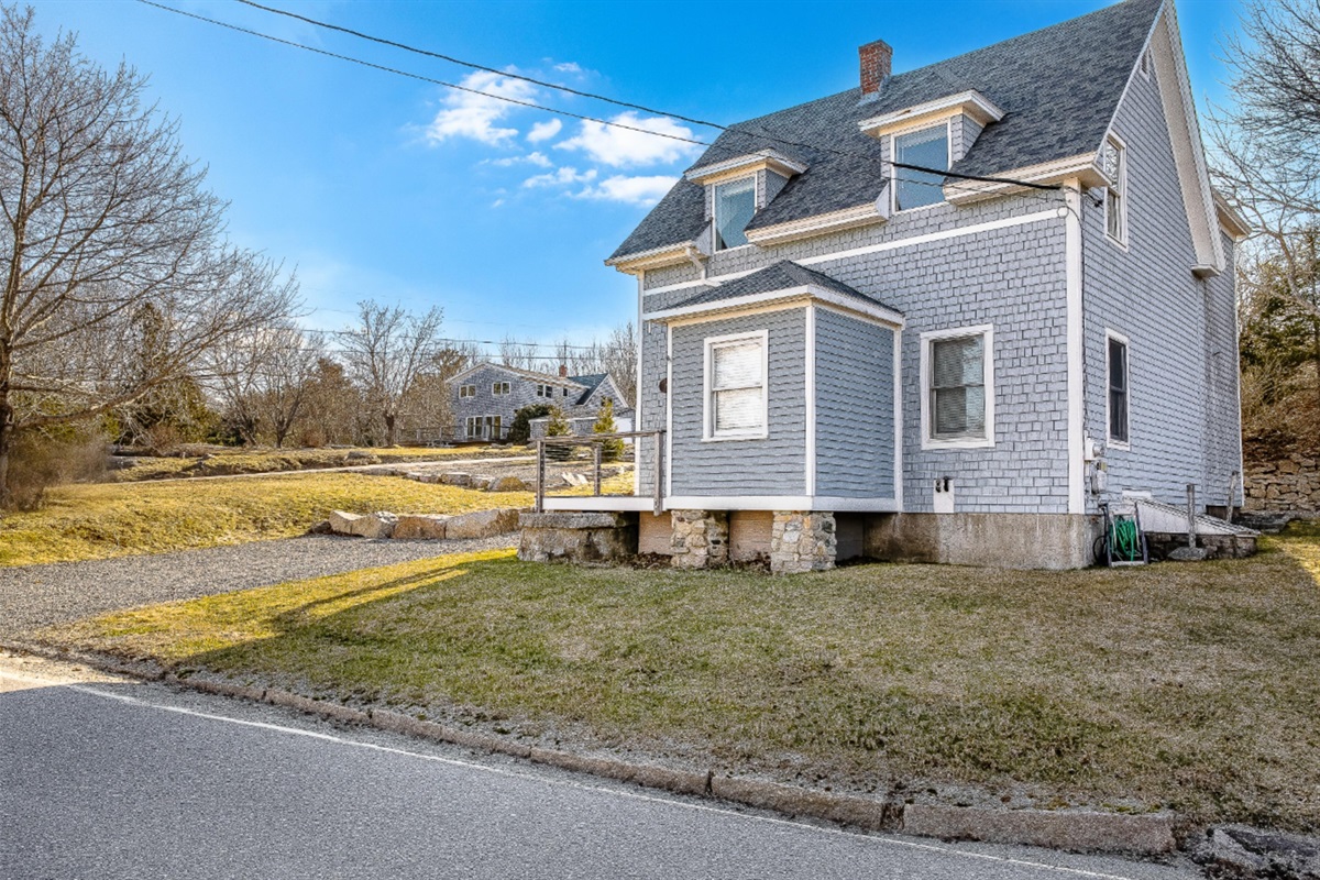 Pull right up and settle in. This angle shows the easy driveway access and the spacious side yard, giving you a real sense of the room you’ll have to spread out and enjoy the fresh Maine air during your stay.
