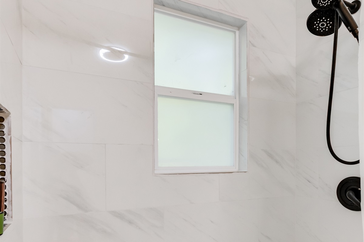Upstairs Full Bathroom 1: Sleek marble tiles and modern fixtures create a refreshing retreat for your stay!
