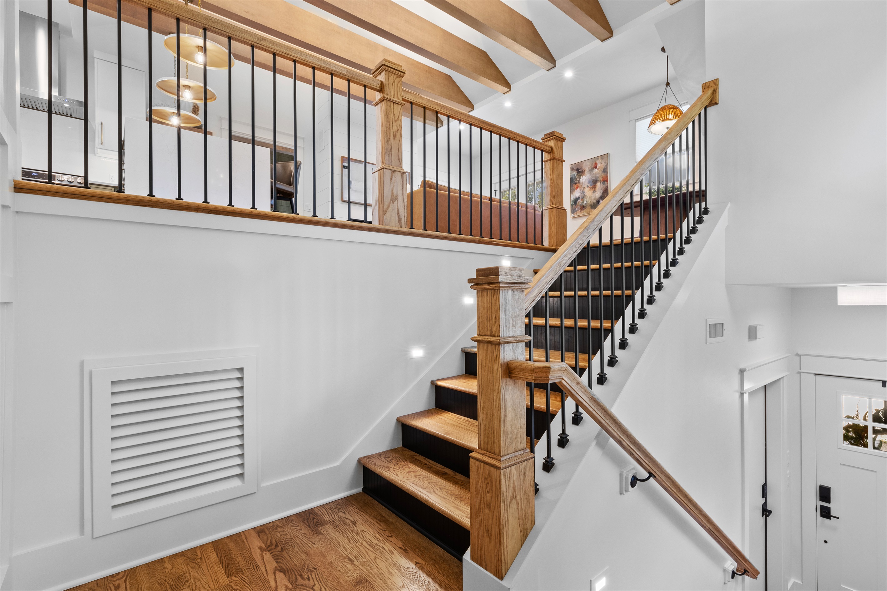 Wide stairwell with warm wood and black metal railing details.