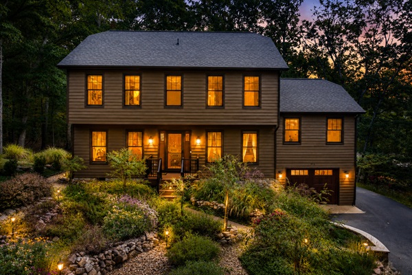 Pull into the driveway at dusk and every window is glowing — the landscaped gardens are lit, the sky is pink, and the house looks exactly like the vacation you promised everyone.