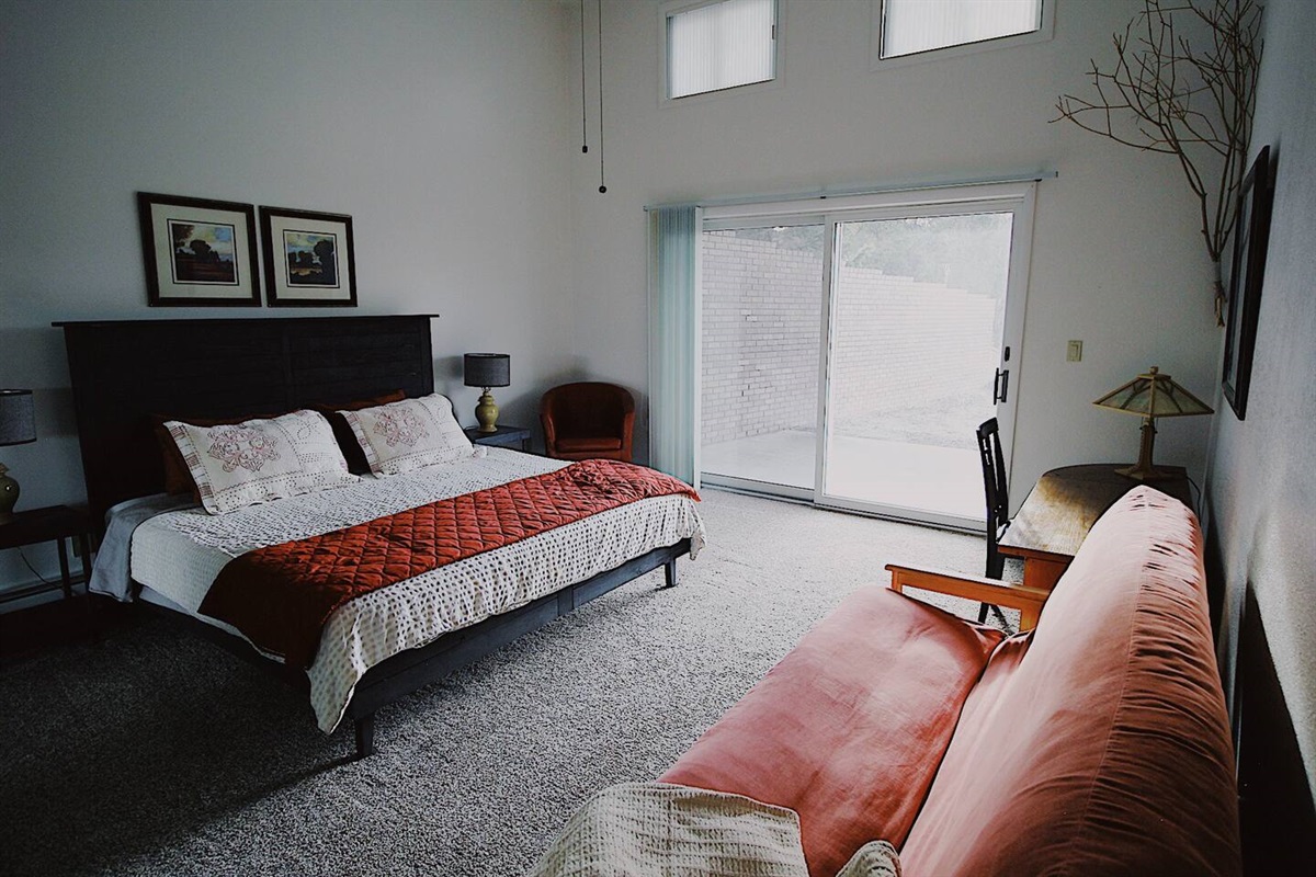  Adjacent to the bed, a plush couch and a stylish red chair await, providing cozy spots to unwind and relax. A perfect blend of colors on the walls and decor to create a harmonious ambiance.