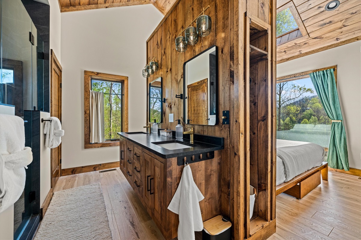 Custom double vanity wall featuring recycled glass light fixtures and floating vanity. Walk around to the bedroom.