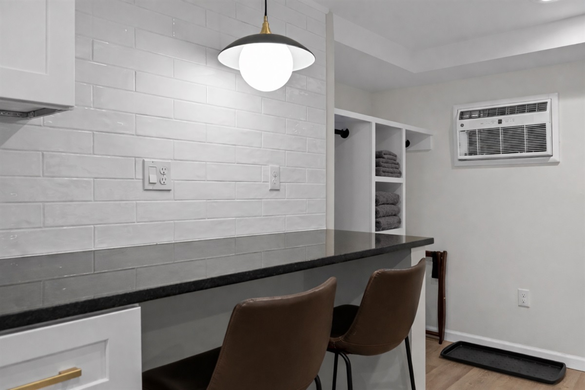 Bright dining nook with bar seating, modern lighting, and clean finishes—perfect for casual meals, coffee breaks, or planning your day.