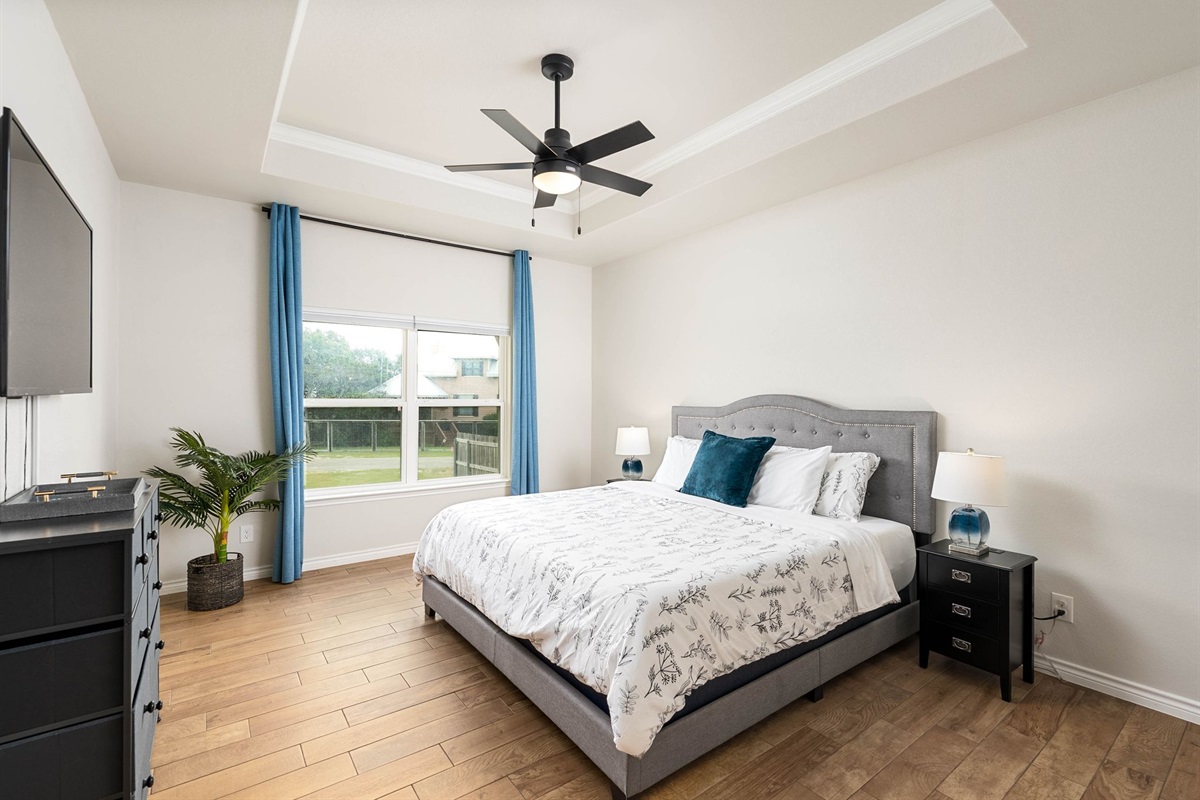Master bedrom with a king size bed. The cordless  blinds can allow you to slide the blind from the top and or bottom to change the amount of outdoor lighting you desire and  privacy.