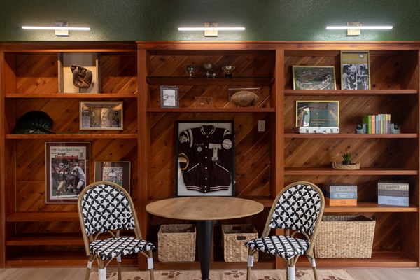 This isn’t your average living room—it’s equal parts vintage varsity and movie-night mood lighting. Think high school trophy case meets curated comfort, with a 65" Smart TV, sound bar and all the nostalgic energy and board games.