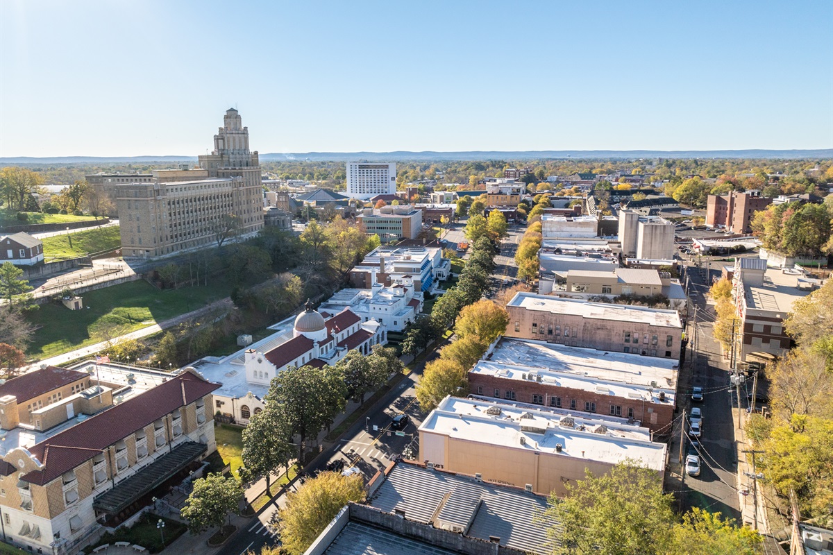 This aerial perspective captures the heart of downtown Hot Springs, showcasing its vibrant blend of historic landmarks, lush greenery, and local culture.