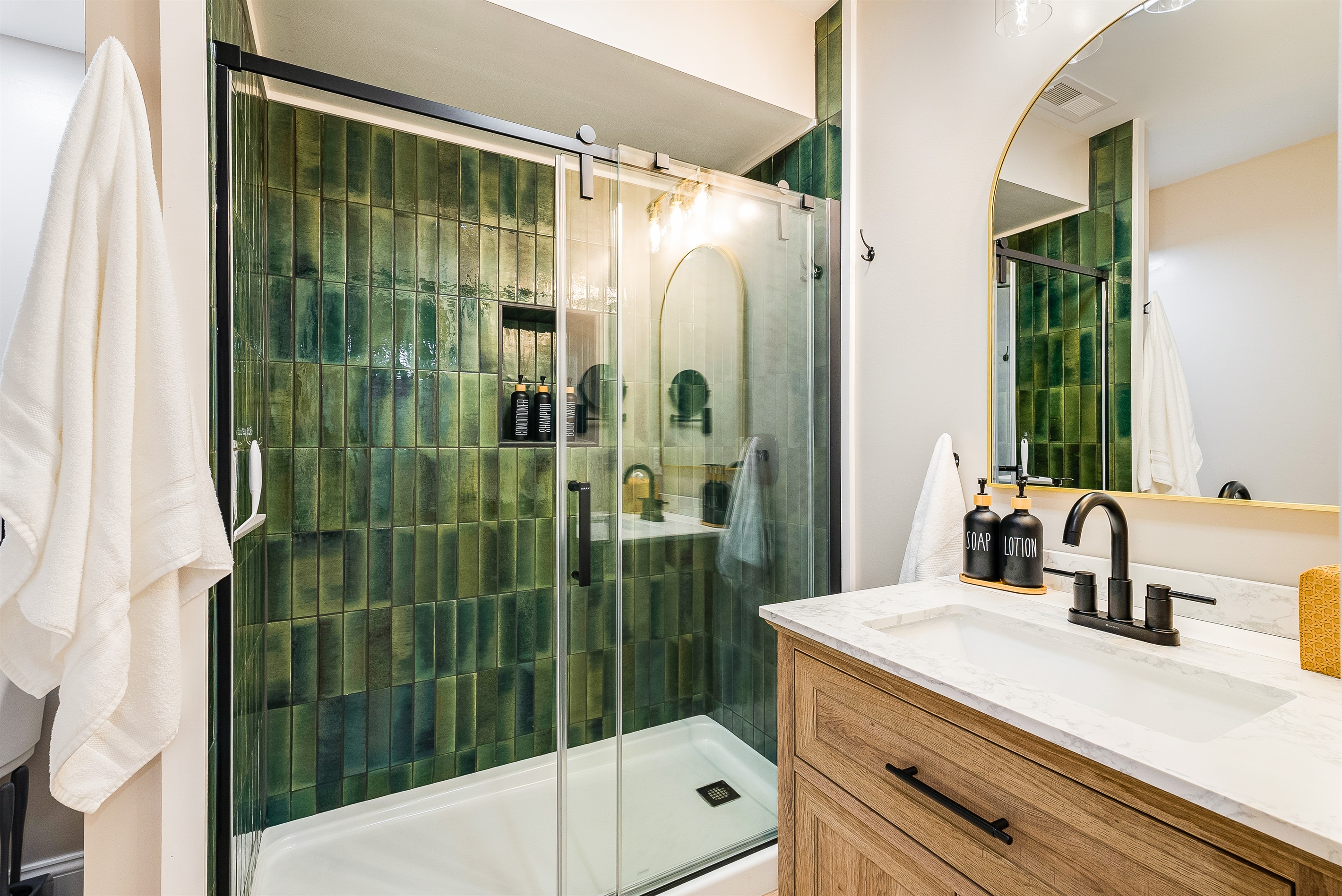 A modern bath with rich green tile and spa-style amenities—perfect for unwinding after a mountain adventure.