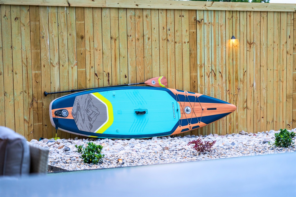 Adventure awaits with our vibrant paddleboard, ready for you to explore the calm waters and beautiful scenery of the lake.