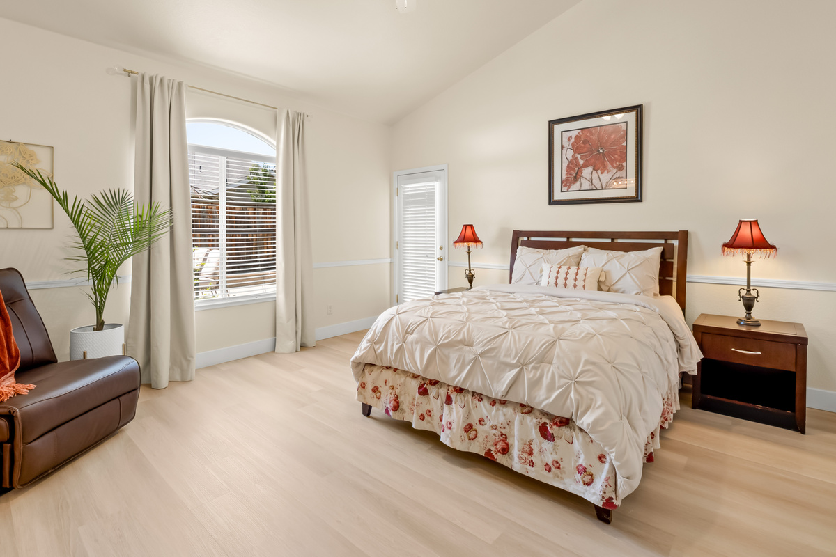 Retreat to this spacious primary suite featuring a plush bed, cozy recliner, and private access to the outdoor patio. Thoughtfully designed for comfort and relaxation, it's the perfect place to unwind after a day of exploring.