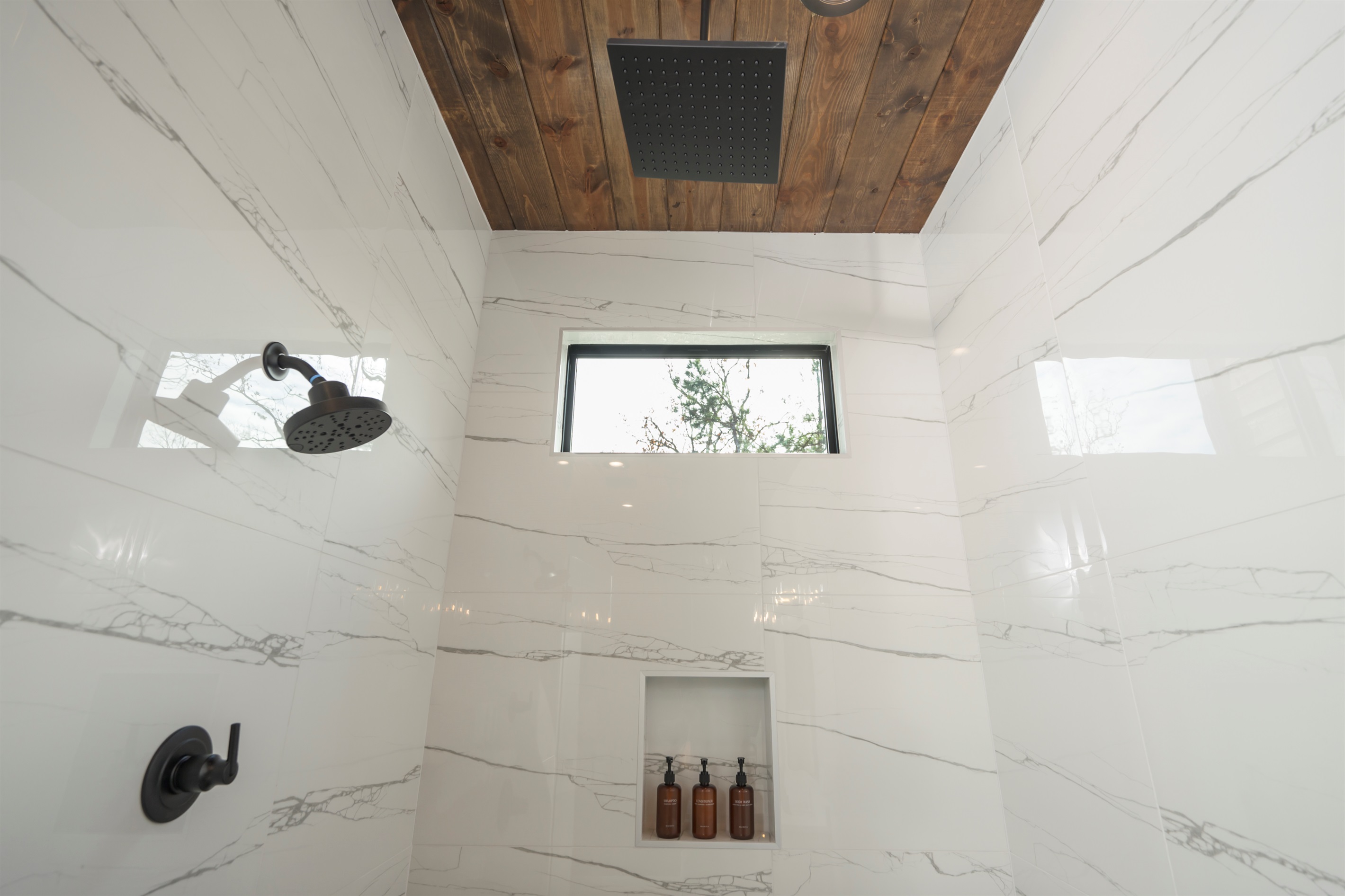 Ensuite Bathroom 1 - Private bathroom attached to King Suite 1. Featuring oversized shower with dual showerheads and spa-quality marble finishes. Includes premium toiletries (body wash, shampoo, conditioner, hand soap) and hotel quality towels. 
