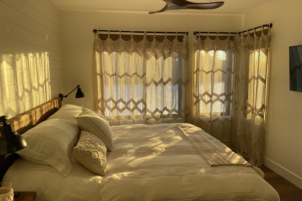 Main floor bedroom with king bed and drapes drawn
