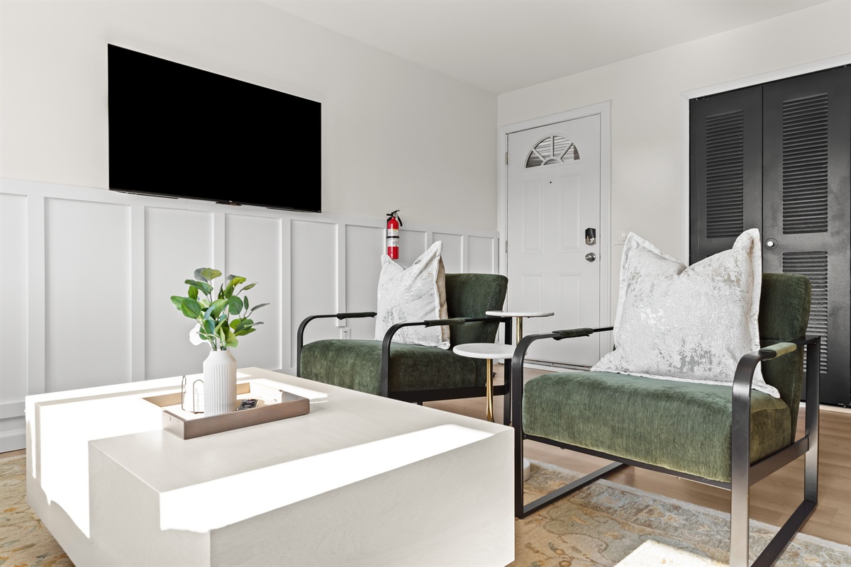 Bright and modern living space featuring a cozy green velvet sofa and minimalist décor.