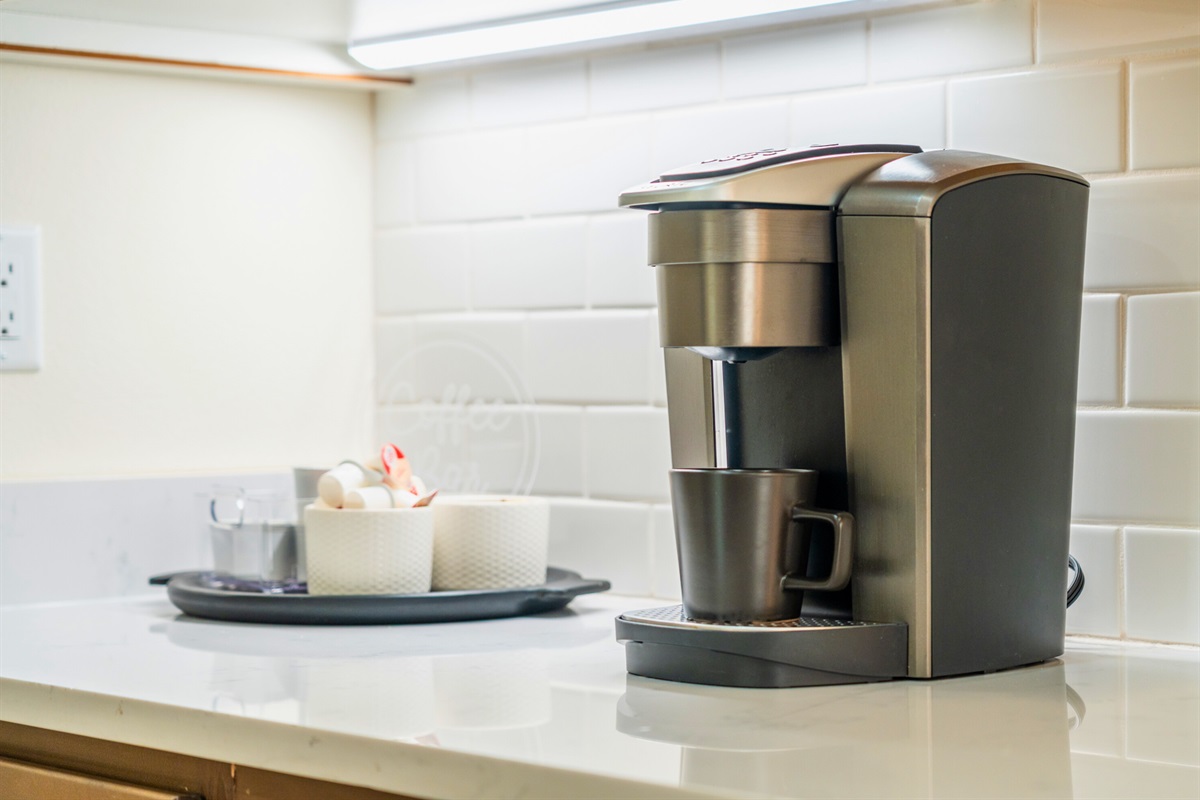Convenient coffee station complete with Keurig, mugs, and essentials to start your day right.