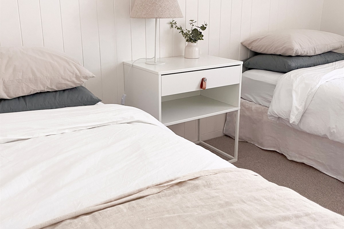 Summers Green View Retreat in Logan Reserve includes a twin bedroom with two single beds and soft neutral bedding for a flexible sleep setup.